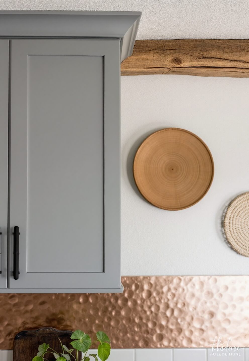 Macro detail shot of kitchen textures, featuring rough wooden ceiling beam, smooth painted cabinets, hammered copper backsplash, woven wall art and dramatic lighting effects.