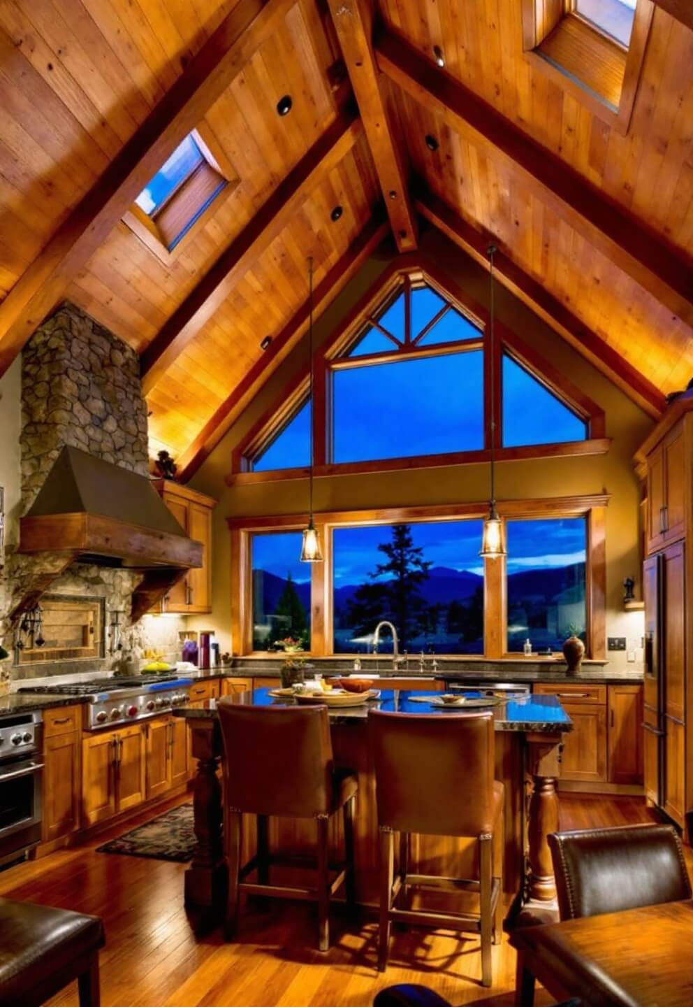 A low angle view of a luxurious 18x20ft kitchen in a mountain lodge featuring vaulted ceiling, clerestory windows casting dramatic shadows at dusk, premium hickory cabinets with craft details, stone hearth, timber beams, and leather bar stools.