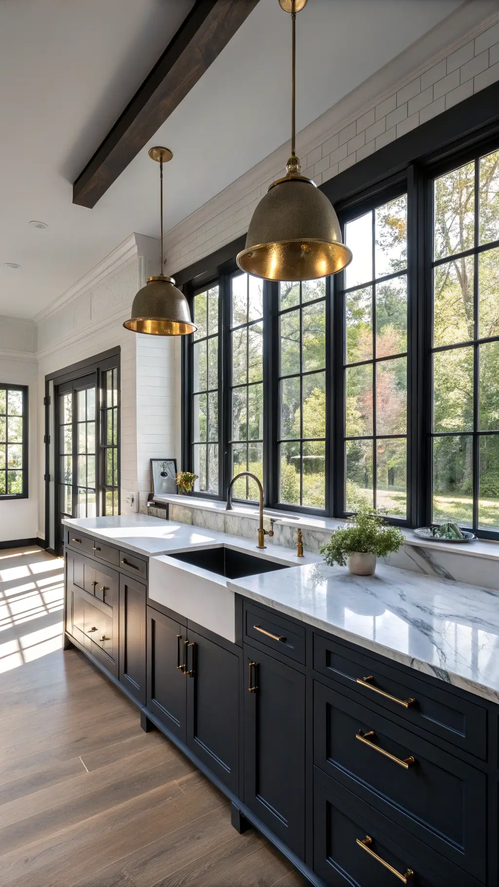 Modern kitchen with navy cabinets, granite countertops, brass accents, and marbled backsplash, bathed in a mix of dramatic afternoon light and warm under-cabinet lighting.