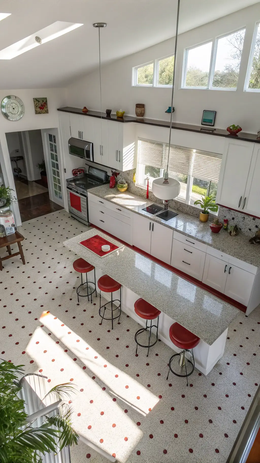 High-angle view of a spacious vintage kitchen with white cabinets, 1940s terrazzo flooring, a cherry red stove, quartz countertop island with mid-century bar stools, milk glass pendant lights, and afternoon shadows falling from plantation shutters.