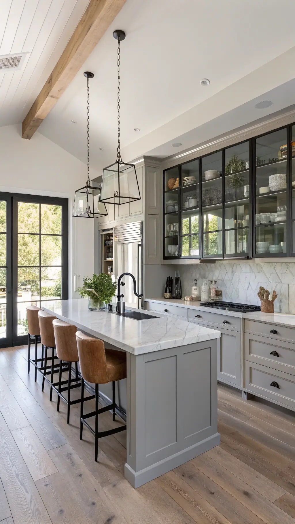Contemporary farmhouse kitchen with dove gray cabinets, black steel and glass pantry doors, marble-topped island with shiplap detail, leather-backed barstools, open shelving displaying minimalist ceramics, and bleached oak flooring in abundant natural light.
