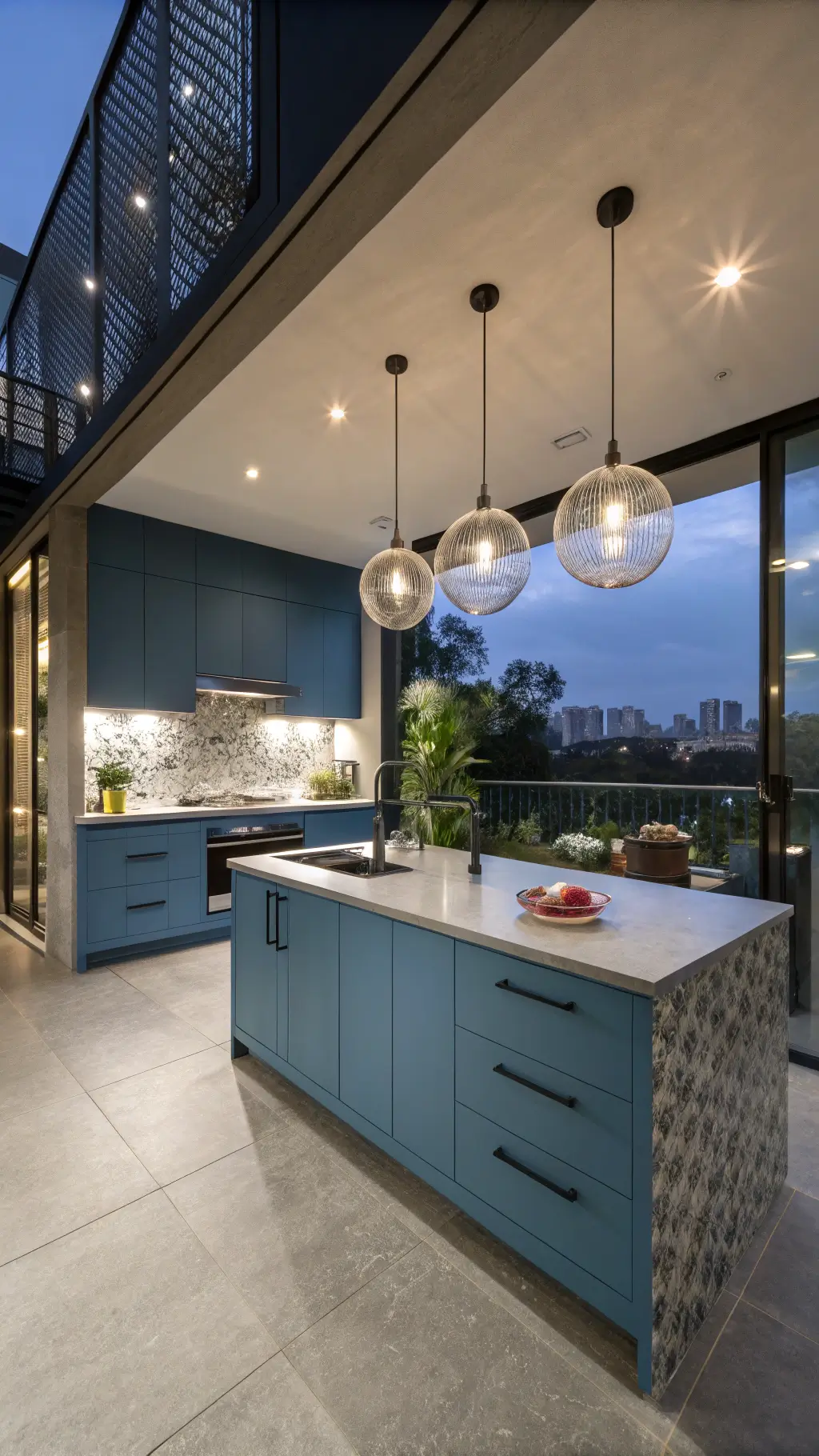 Sleek open-concept kitchen with powder blue and charcoal cabinets, concrete countertops, and metallic tile backsplash under modern glass pendant lights at dusk